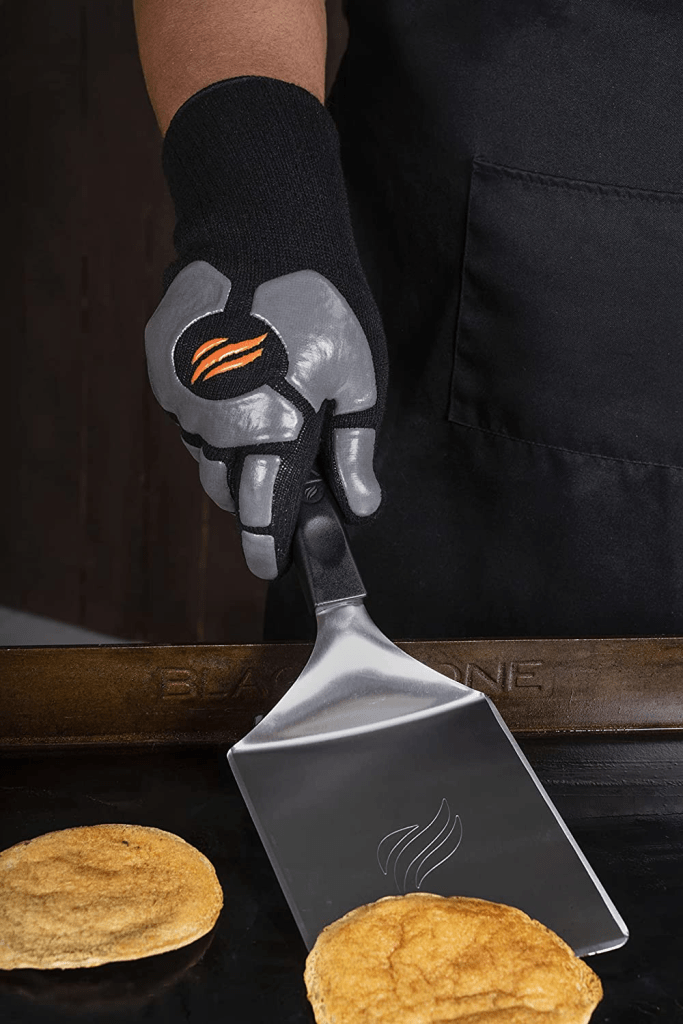 Investing in a pair of heat-resistant gloves is essential for cooking on a griddle, as the surface will be piping hot and have hot grease on it. Gloves allow you to work your magic on the griddle without fear of serious injury.
