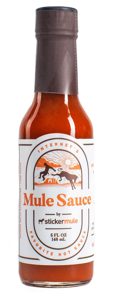 Mule Sauce Hot Sauce Bottle The bottle is a simple and straightforward design. It's a 5 oz clear glass bottle with a black screw-top lid. The label is minimalistic with the company's logo and the sauce's name in bold lettering. The label also includes the ingredients and nutritional information.